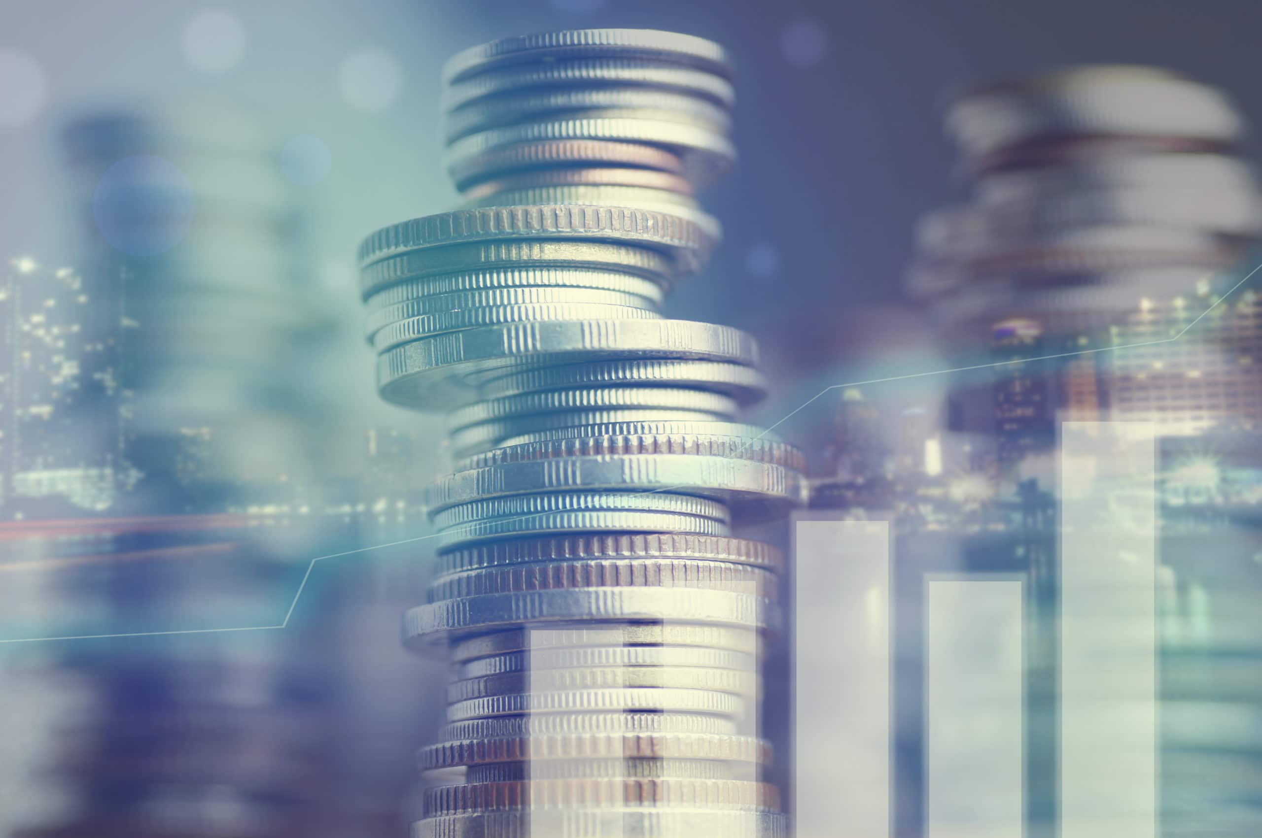 Double exposure of city and graph on rows of coins for finance and banking concept